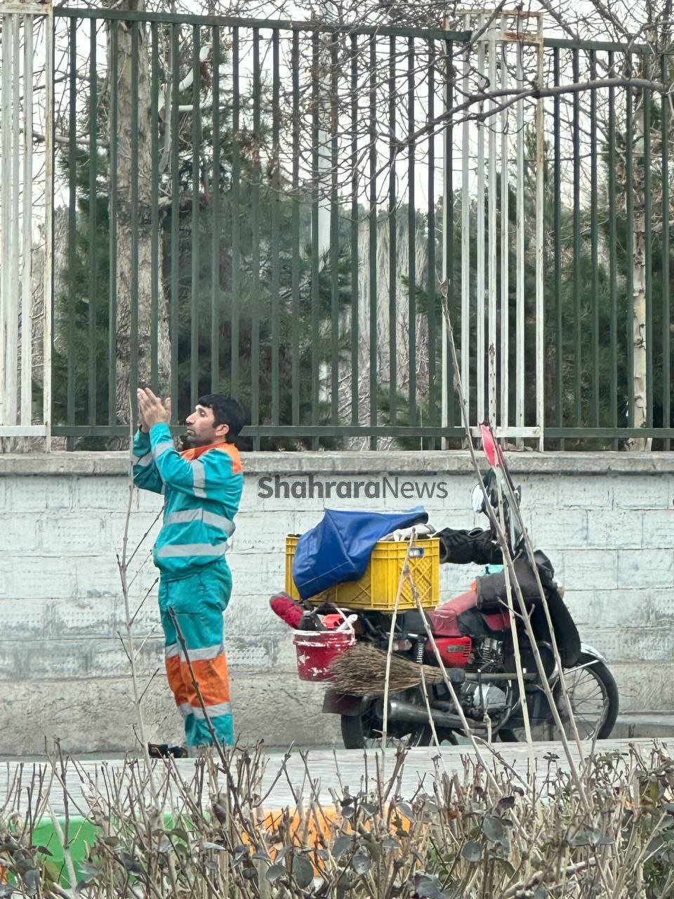 تصویری زیبا از نماز خواندن پاکبان مشهدی در کنار خیابان+ عکس