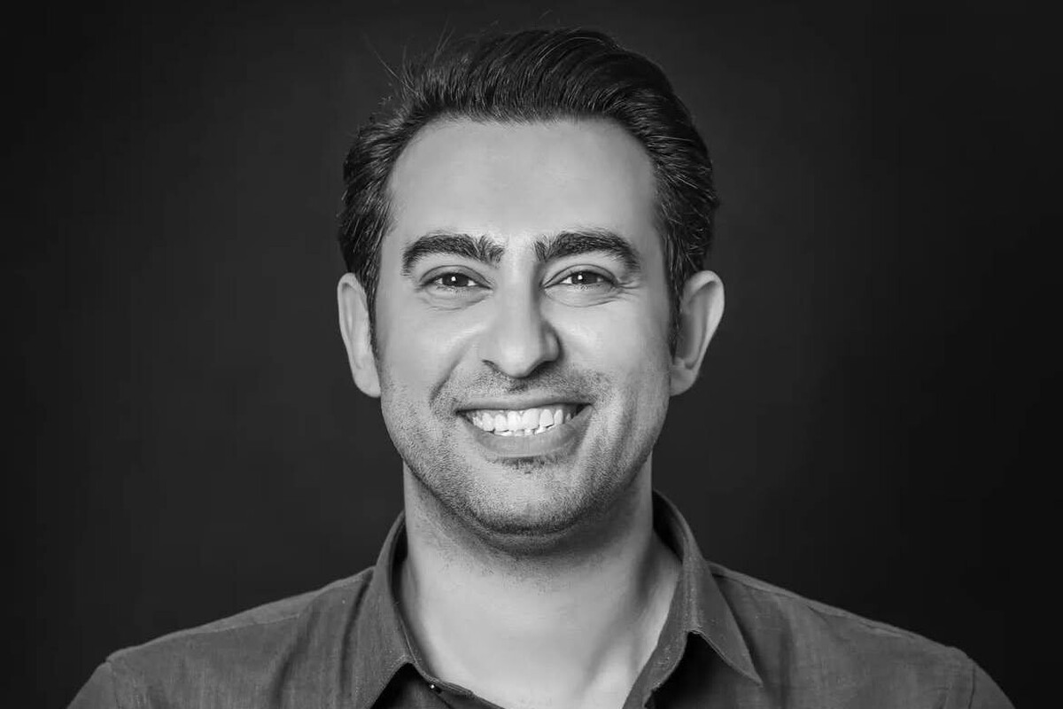 برای میلاد قنبری، موسیقی نه از کلاس و دانشگاه، که از کوچه و محله‌های قدیمی آغاز شد. اولین تصویرش از صدا، برمی‌گردد به شش‌سالگی: طبل‌های بزرگ، نیسان آبی قدیمی و نوازنده‌ای که ایستاده بر بام خودرو، بر ریتم دسته عزاداری ویلن می‌زد. همان صداها و همان جمعیت‌های پرهیاهو، نخستین جرقه‌های کنجکاوی او را روشن کردند. سال‌ها بعد، مسیرش از کلاس‌های آهنگسازی به صحنه‌ی تئاتر رسید. روزی که تنها برای یک تست خوانندگی رفته بود، اتفاقی مسیر زندگی‌اش تغییر کرد؛ آهنگساز نمایش کنار کشید و او پیشنهاد داد که موسیقی کار را بسازد. به بهانه‌ی حضور او در جمع ما نشستیم و درباره‌ی تجربه‌های زیسته‌اش، پیوند موسیقی و تئاتر، و مسیری که از کوچه‌های قدیمی تا صحنه‌های رسمی طی کرده، گفت‌وگویی صمیمی انجام دادیم.