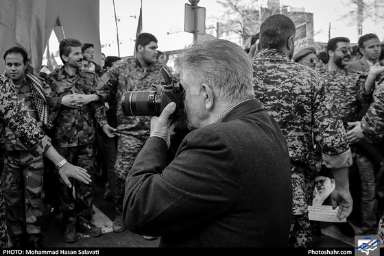 راهپیمایی شروع شده و صف اول را برادران بسیج در حالی که برای کنترل حرکت جمعیت دستان خود را به یکدیگر حلقه کرده اند تشکیل داده اند و آقای عربلین در حال عکاسی از صف اول و نیروهای بسیج است.