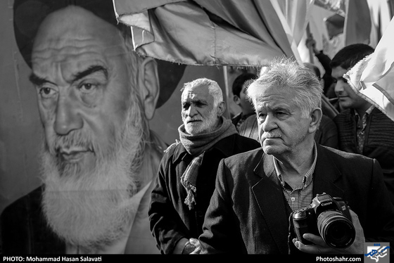 آقای عربلین مقابل یکی از تابلو نقاشی های قدیمی از امام خمینی . این تابلو نقاشی چندین سال است که در صف اول تمام راهپیمایی همراه مردم حرکت میکند.