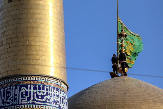 اهتزاز پرچم عزای حسینی بر فراز گنبد حرم رضوی