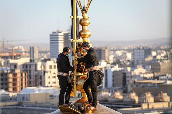 اهتزاز پرچم عزای حسینی بر فراز گنبد حرم رضوی