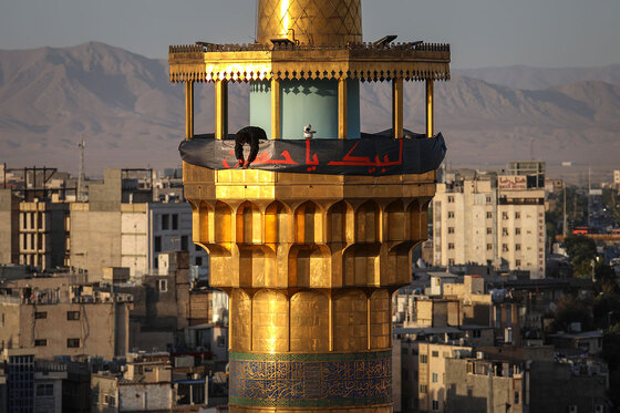 اهتزاز پرچم عزای حسینی بر فراز گنبد حرم رضوی