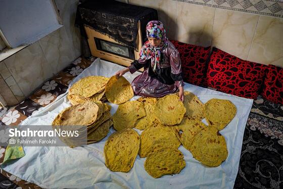 نوه فاطمه خانم نان ها را برای خنک شدن پهن می کند