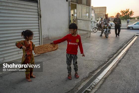 بهمن نانی را که از طریق نذر نان گرفته است به خواهرش نازگل می‌دهد