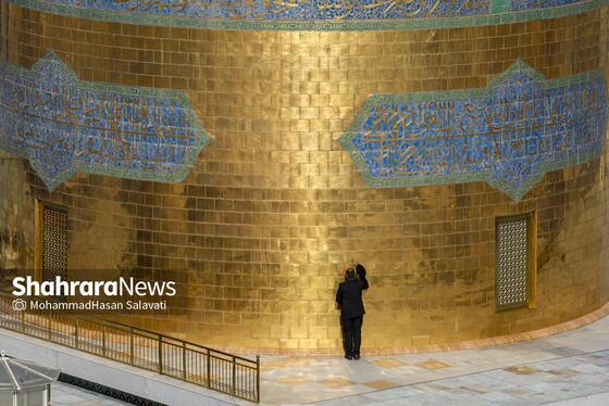  یکی از خدام در حال بوسیدن گنبد منور رضوی قبل از شروع آیین صلا می باشد