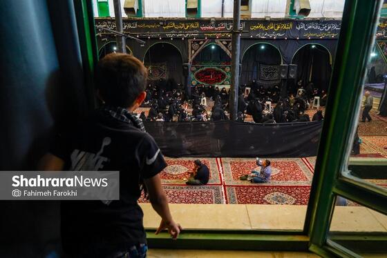 کودکی از طبقه بالا در حال تماشای حسینیه است
