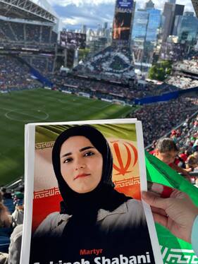 تصاویر شهدای لامرد در دست تماشاگران در بازی ایران مقابل مصر